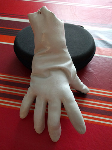 La Chose (main blanche coupée) faite-maison qui se tient à peu près sur ses doigts (avec un support derrière)